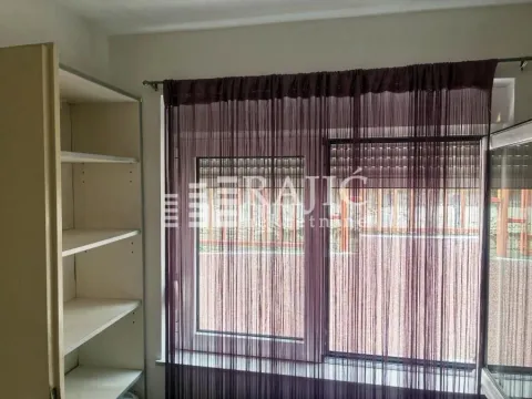 View of a window with dark curtains and shelves on the left side. - image 9