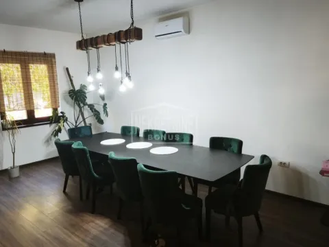 Trpezarija sa velikim crnim stolom i zelenim stolicama. - image 12