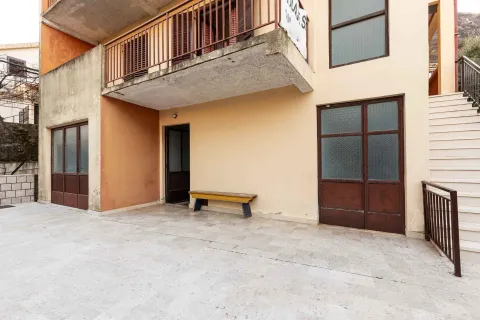 Pogled na spoljašnji dio kuće sa popločanim dvorištem i terasom na spratu. - image 29