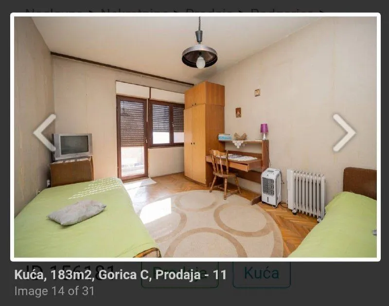 Manja spavaća soba sa dva kreveta, radnim stolom i ormarom.