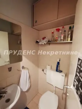 Small bathroom with a sink, toilet, and wall cabinet. - image 5