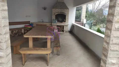 Natkrivena terasa sa zidanim roštiljem i drvenim stolom za sjedenje. - image 6