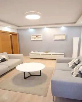 Dnevna soba sa garniturom za sedenje, stočićem i TV komodom. - image 2
