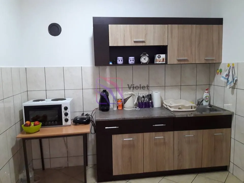 Manja kuhinja sa drvenim elementima i sudoperom.