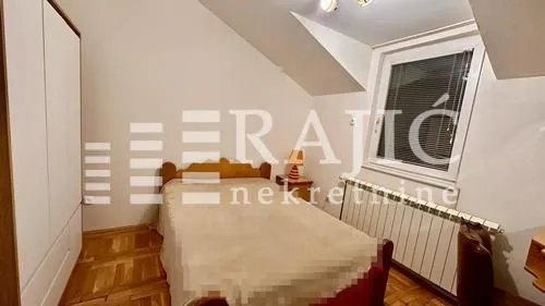 Smaller bedroom with a double bed, wardrobe, and sloping ceiling.