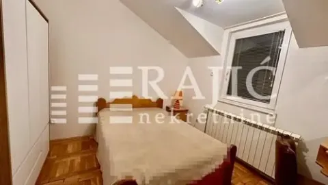 Smaller bedroom with a double bed, wardrobe, and sloping ceiling. - image 10