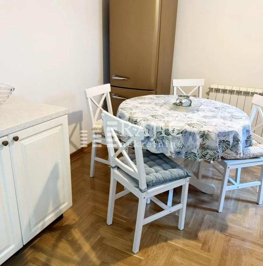 Dining area with a table, chairs, and kitchen units.