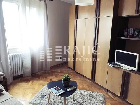 Living room with a sofa, large wooden wardrobe, and parquet flooring. - image 3