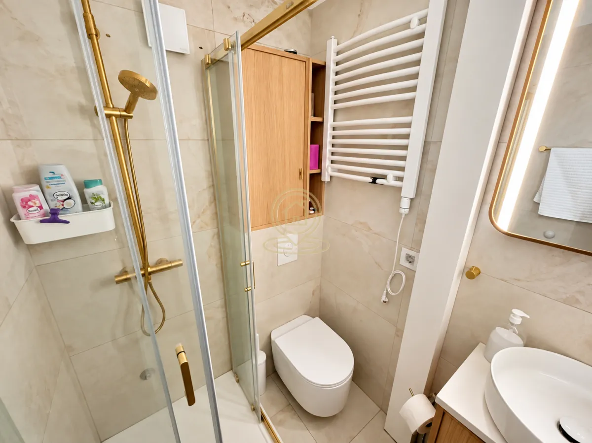 Moderno opremljeno kupatilo sa tuš kabinom, wc šoljom i umivaonikom.