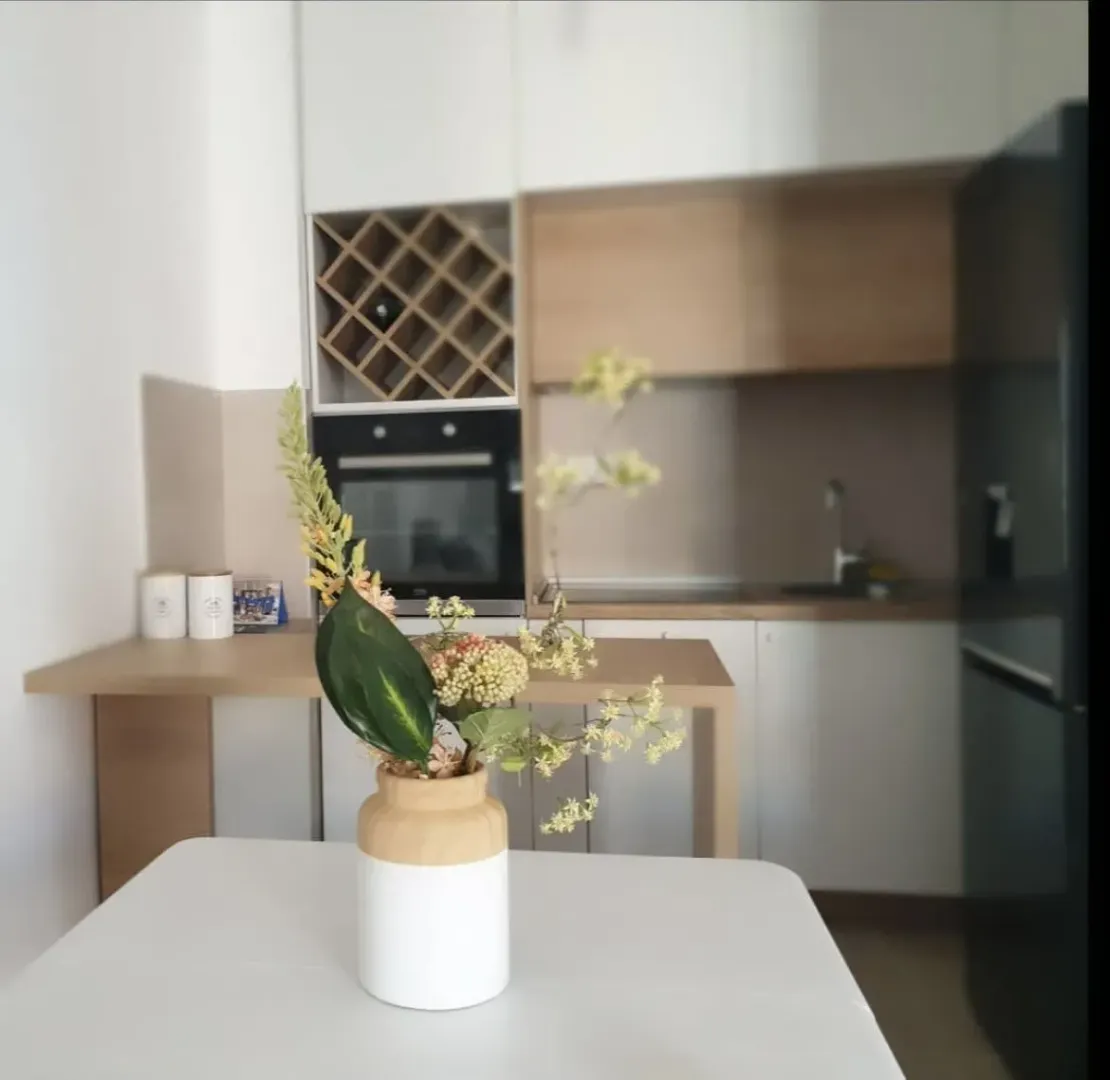Bright kitchen featuring a dining table and decorative vase.