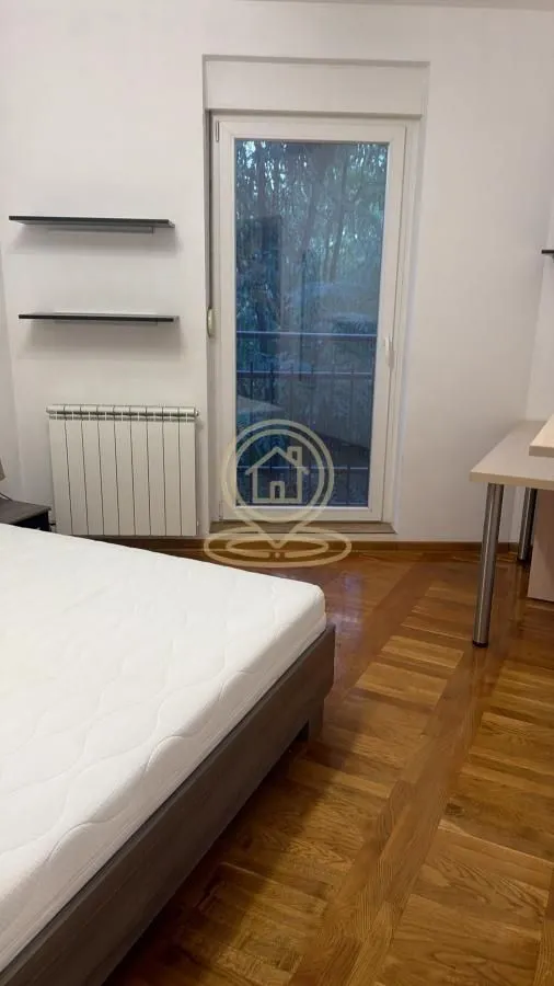 Spavaća soba sa krevetom i izlazom na terasu.