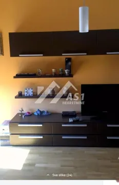 Dnevna soba sa televizorom i zidnim elementima na žutom zidu. - image 3