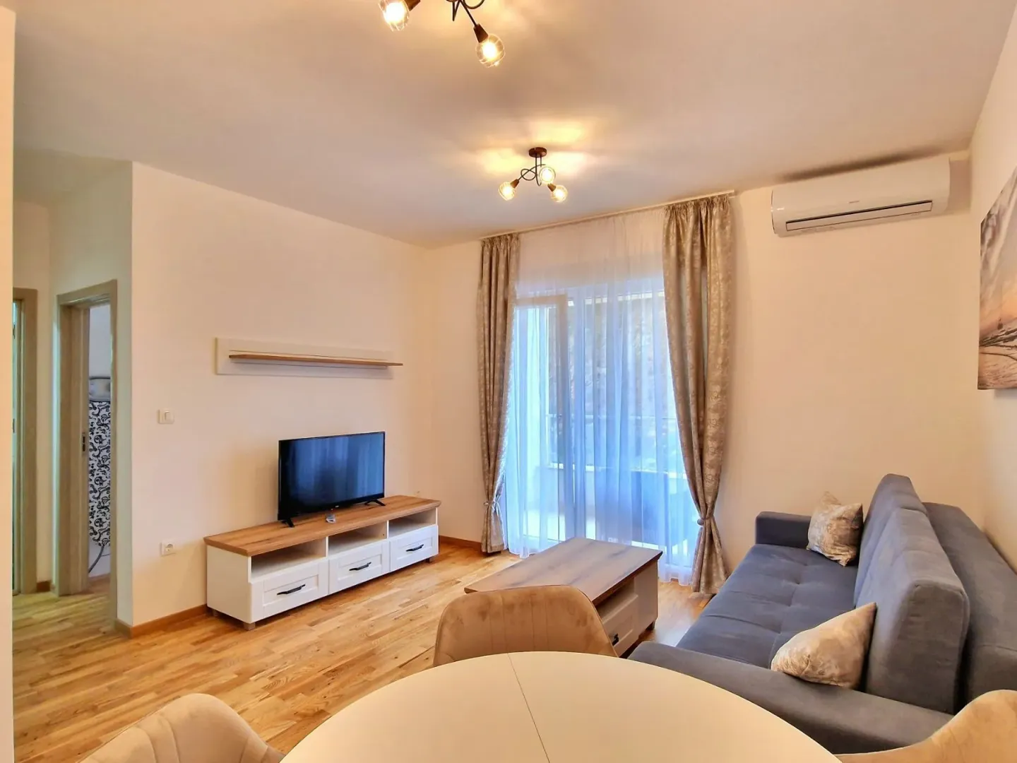 Living room with a sofa, TV, and dining table.