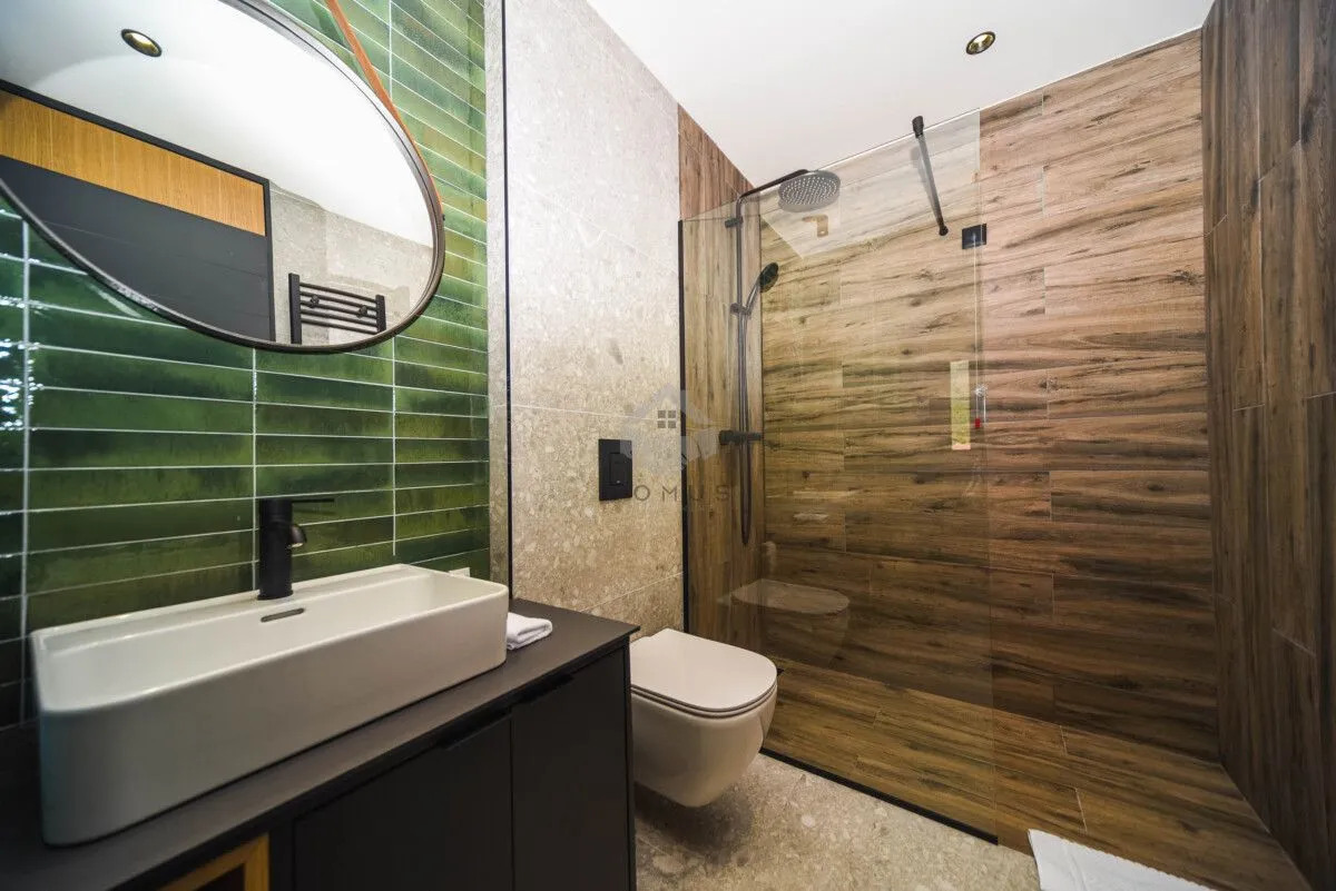 Moderne kupatilo sa umivaonikom, tuš kabinom i ugradnom wc šoljom.
