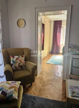 Dnevni boravak sa foteljom i pogledom na sobu kroz otvoren prolaz. - image 4