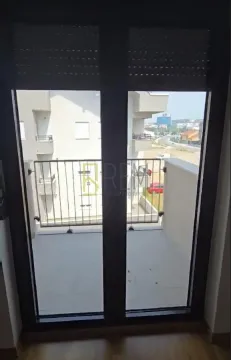 Pogled kroz balkonska vrata na terasu i okolne zgrade. - image 3