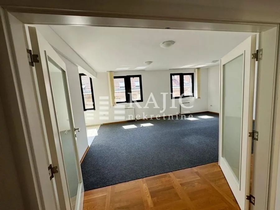 Empty spacious room with parquet flooring and white interior doors.
