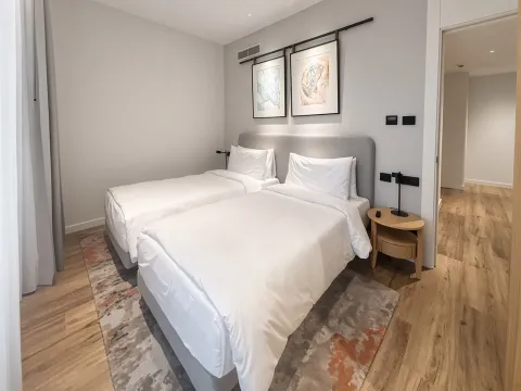 Moderna spavaća soba sa dva odvojena kreveta i noćnim stočićem. - image 12