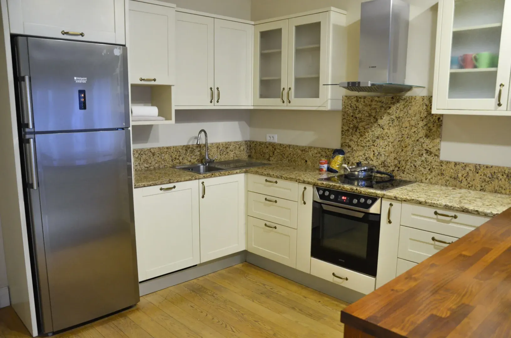 Kitchen with wooden cabinetry, refrigerator, and built-in oven.