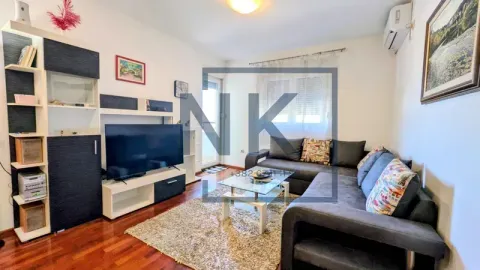 Living room with a sofa, TV and shelving units. - image 2