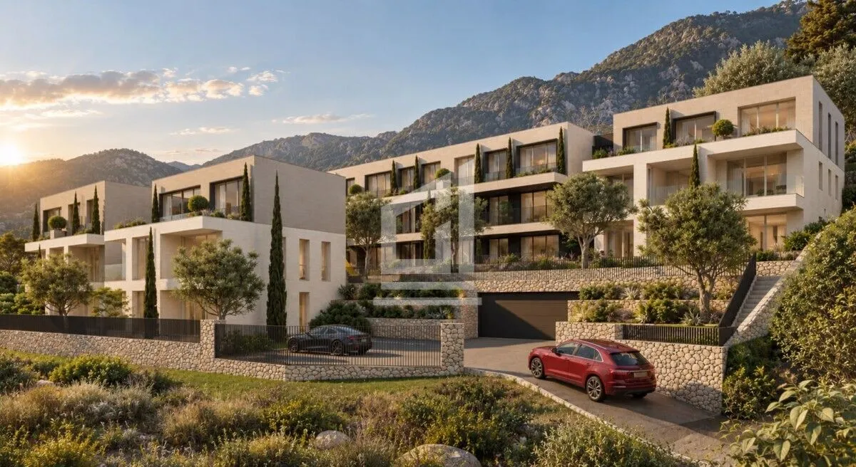 Spoljašnji izgled moderne stambene zgrade sa uređenim dvorištem i planinskim pejzažem u pozadini.