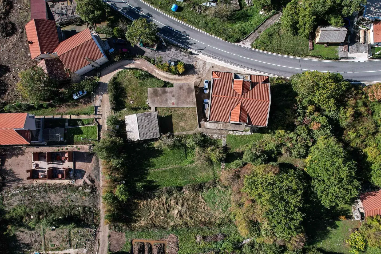Pogled iz vazduha na kuću sa dvoriijem i okolnim zelenilom.
