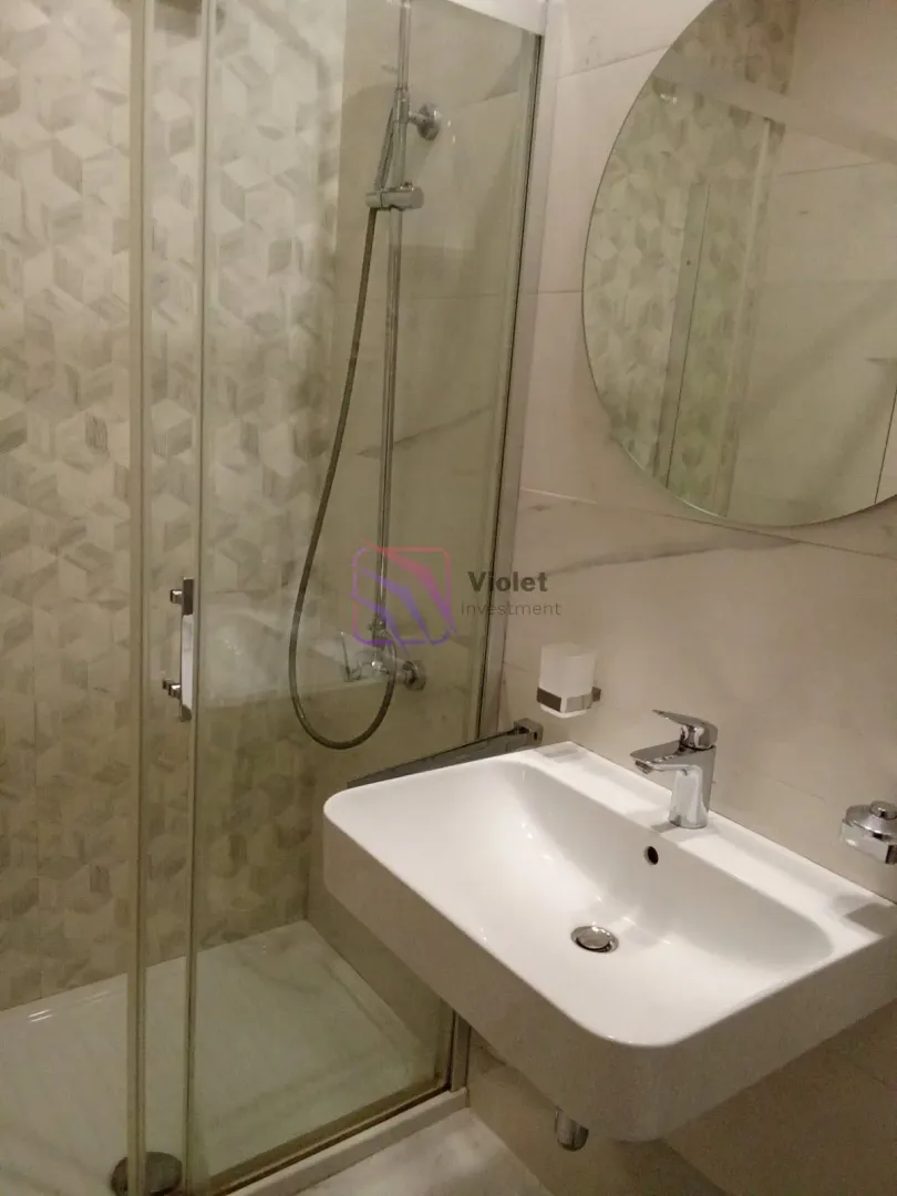 Modernly equipped bathroom with a shower cabin and a washbasin.
