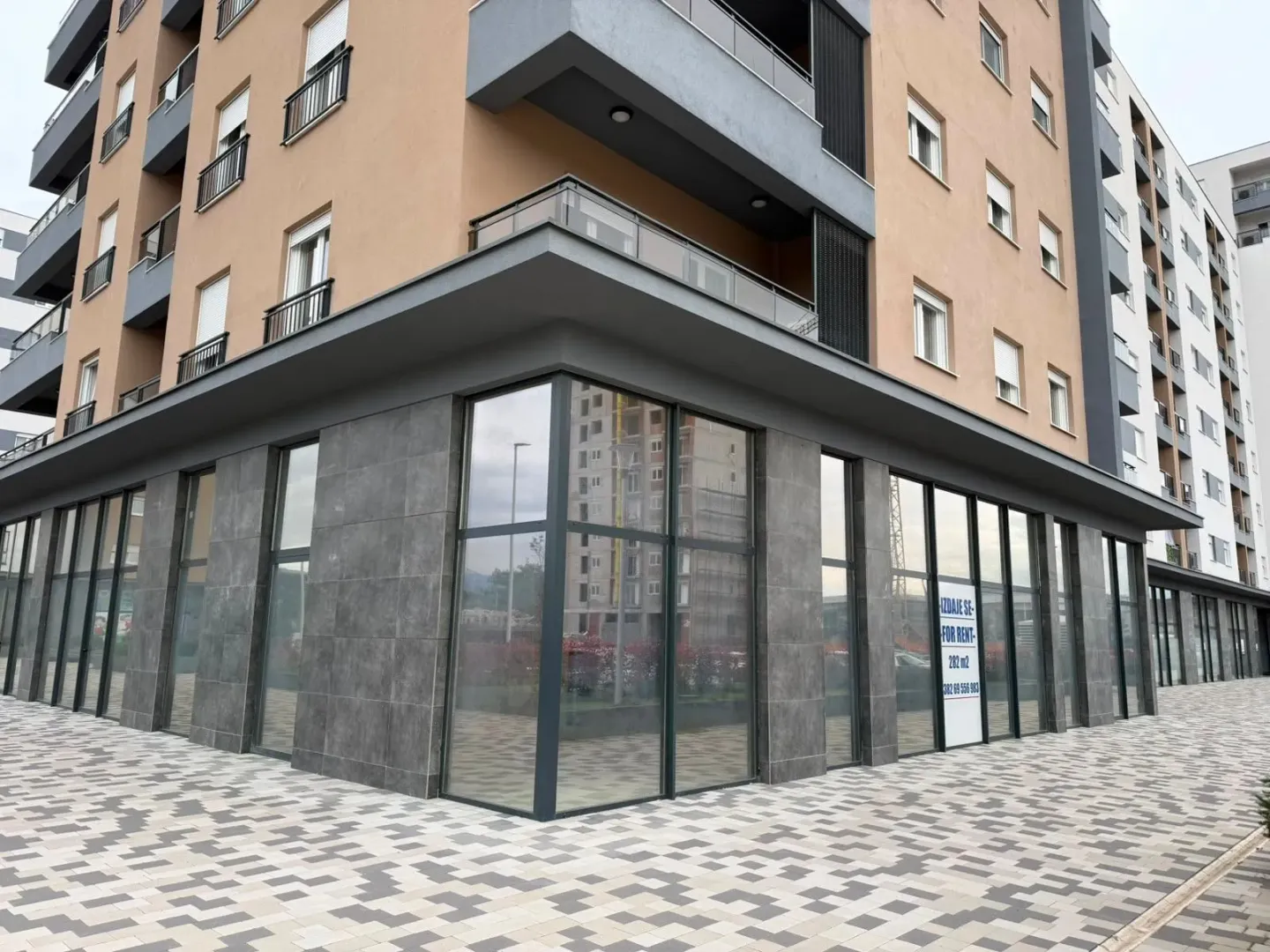 Exterior of a modern residential building with commercial space on the ground floor.