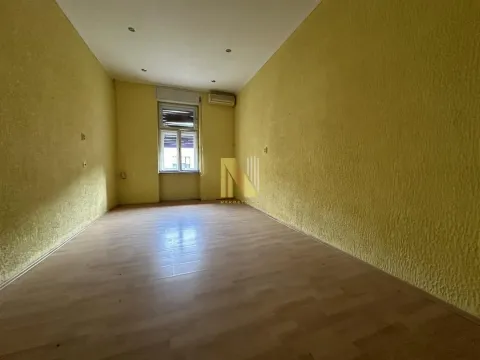 Prazna prostorija sa žutim zidovima i laminatom. - image 9