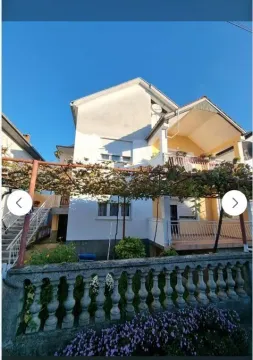 Dvospratna kuća sa uređenim dvorištem i lozom ispred terase. - image 6
