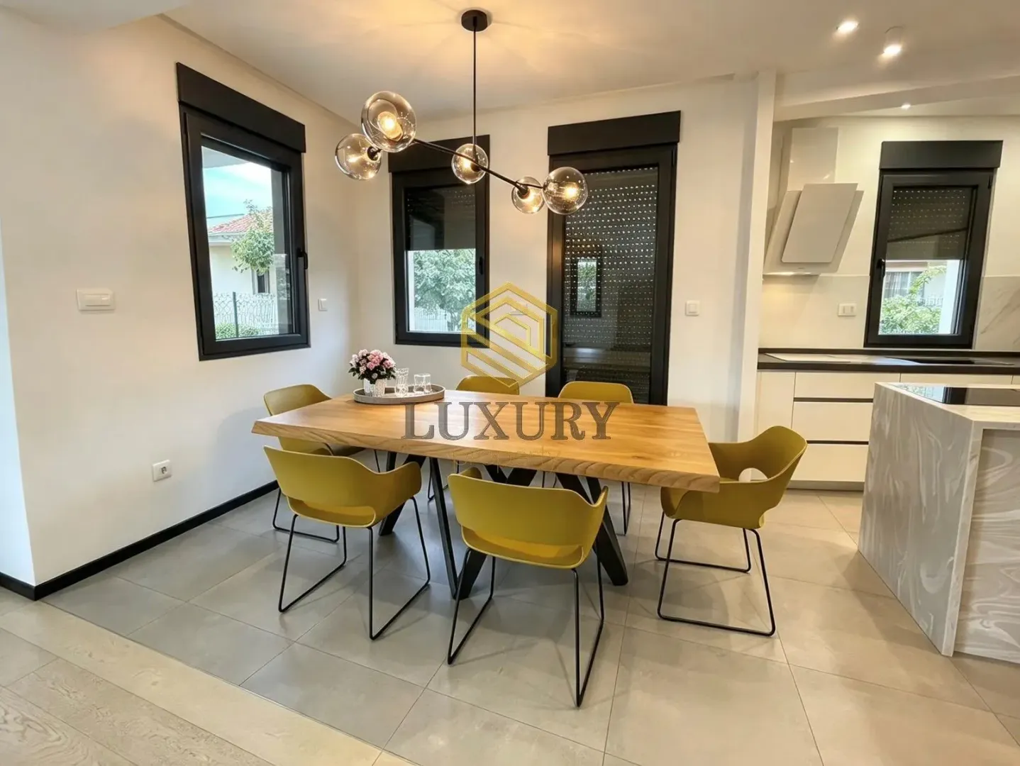 Dining area with a wooden table and modern yellow chairs connected to the kitchen.