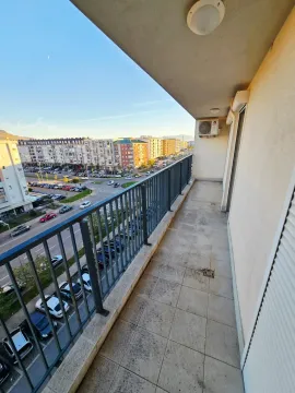 Dugačak popločani balkon sa metalnom ogradom i pogledom na ulicu i grad. - image 12