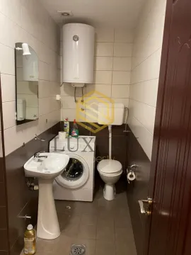 Smaller bathroom with a sink, toilet, washing machine, and water heater. - image 5