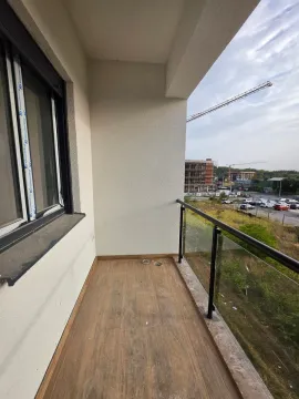 Prazan nenamješten balkon sa pogledom na okolinu i gradilište. - image 10