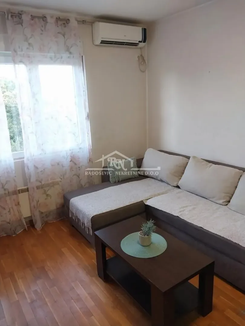 Dnevna soba sa garniturom za sedenje i stočićem.