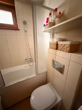 Manje kupatilo sa kadom, toaletom i policama za odlaganje. - image 10