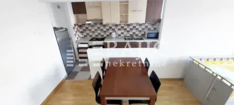 Kitchen with dining area and a wooden table. - image 3