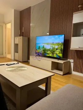 Dnevna soba sa televizorom, drvenim zidnim panelima i klub stolom. - image 7