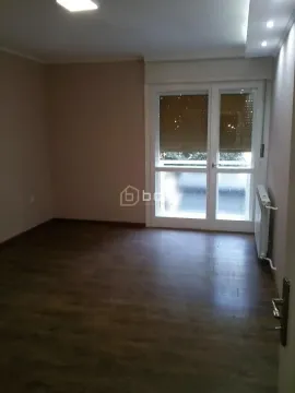 Empty room with dark parquet flooring and balcony doors. - image 4