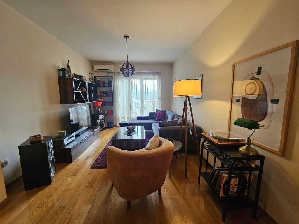 Furnished living room with sofa, armchair and TV unit.