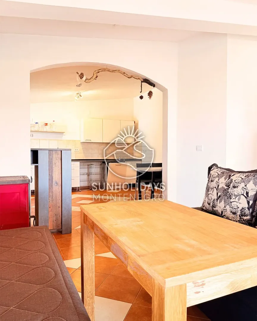 Living room with a dining table and a view of the kitchen.