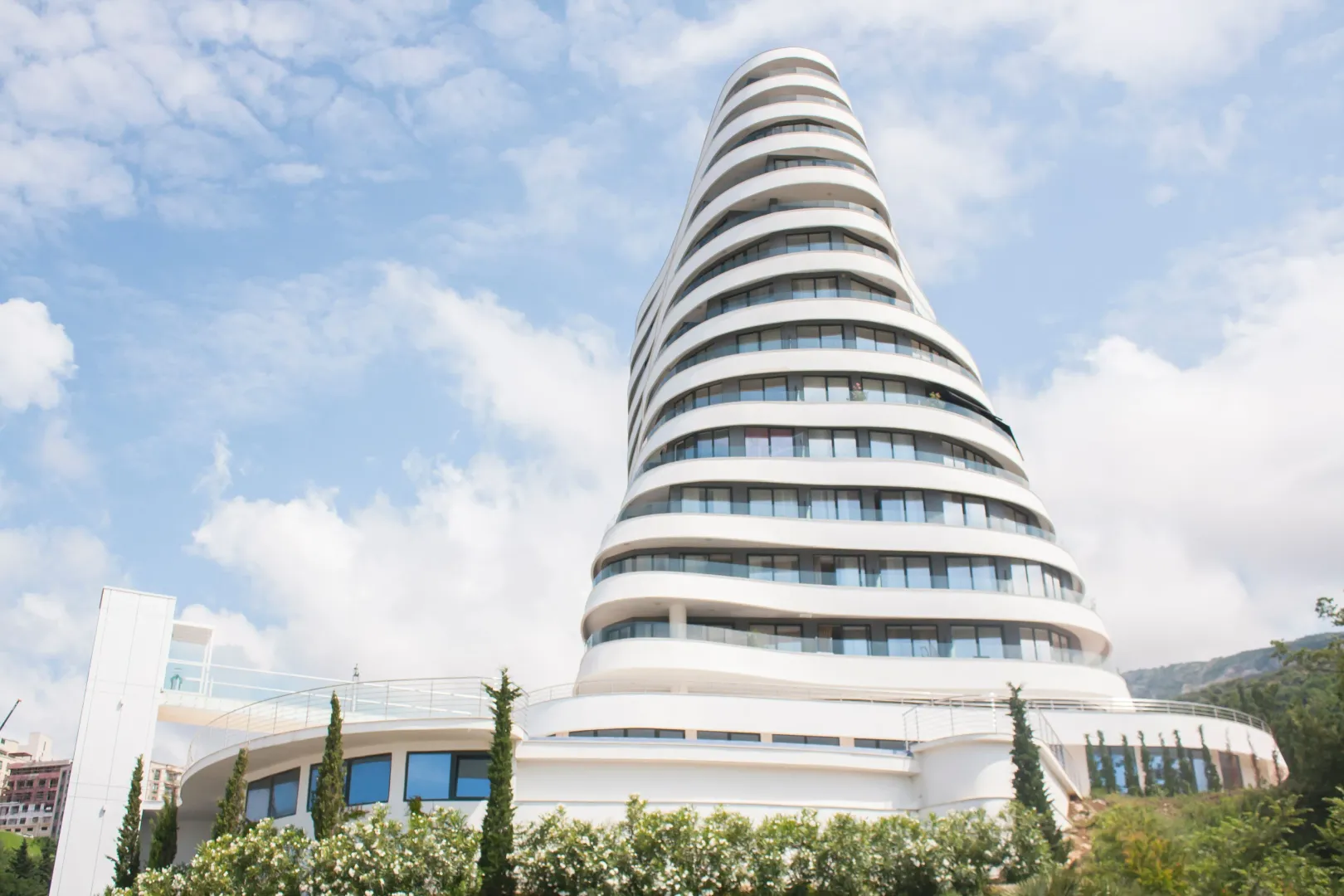 Pogled na modernu višespratnu zgradu neobične arhitekture sa terasama.