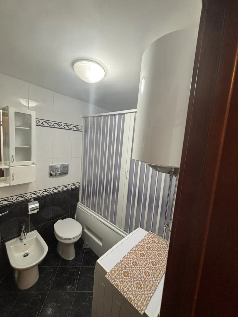 A functional bathroom featuring a bathtub, bidet, and washing machine.