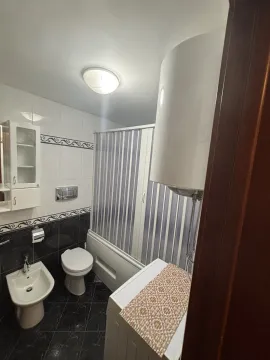 A functional bathroom featuring a bathtub, bidet, and washing machine. - image 8
