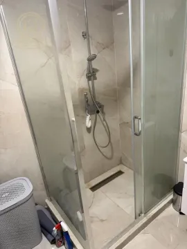 Modern walk-in shower with glass partition and marble tiles in the bathroom. - image 11