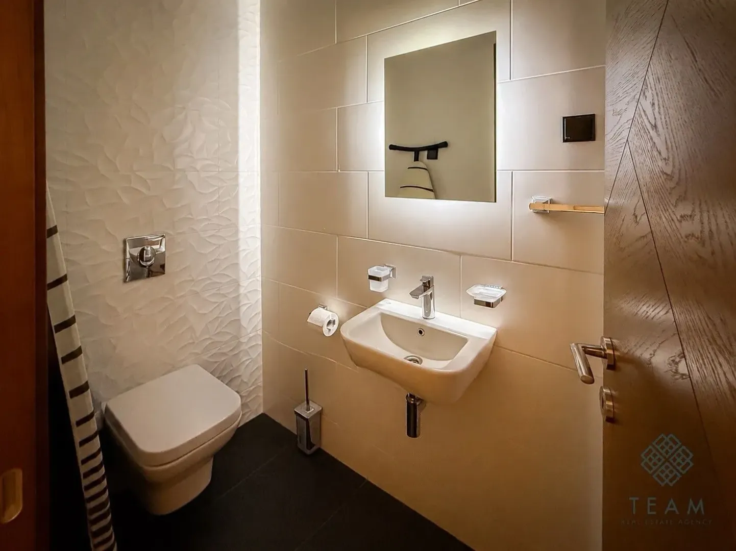 Moderno opremljeno kupatilo sa umivaonikom, ogledalom i wc šoljom.