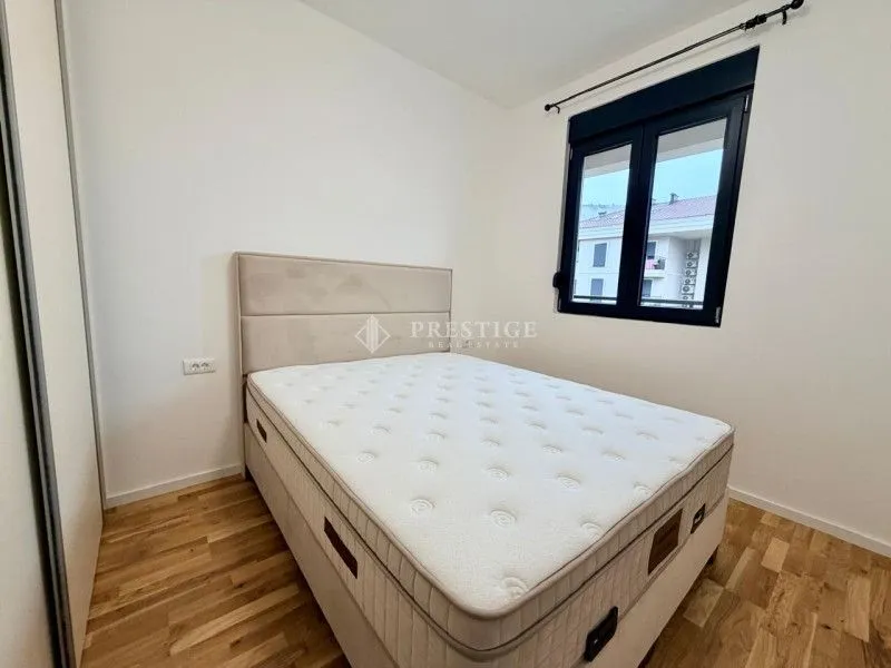 Bright bedroom with a double bed, wardrobe, and window.