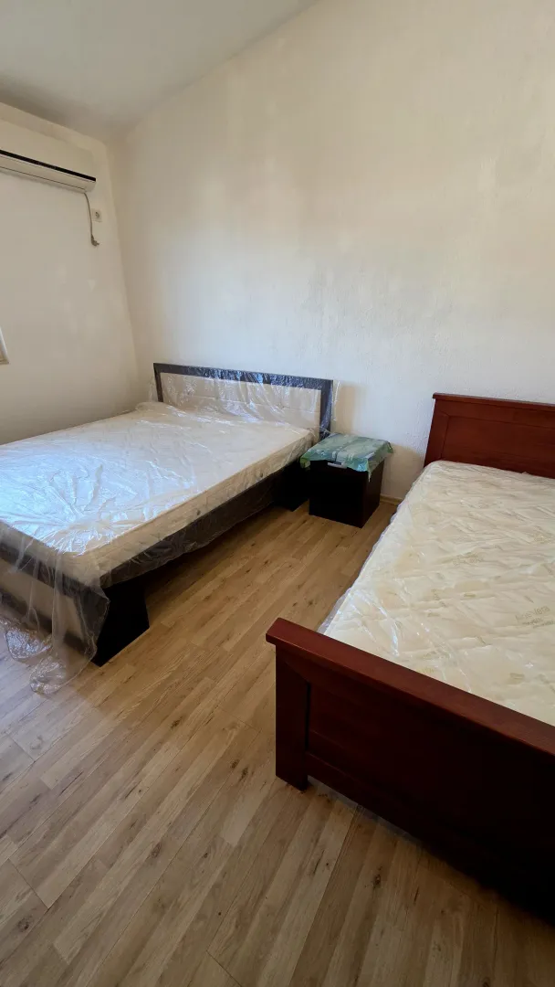 Spavaća soba sa dva kreveta i laminatom.
