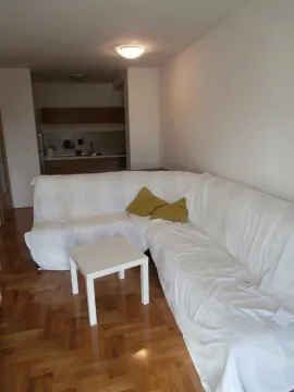 Living room with a corner sofa covered in a white slipcover and a small coffee table. - image 2