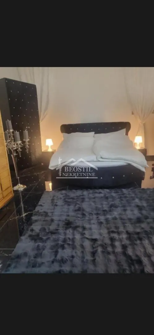 Bedroom with a double bed and dark floor tiles.